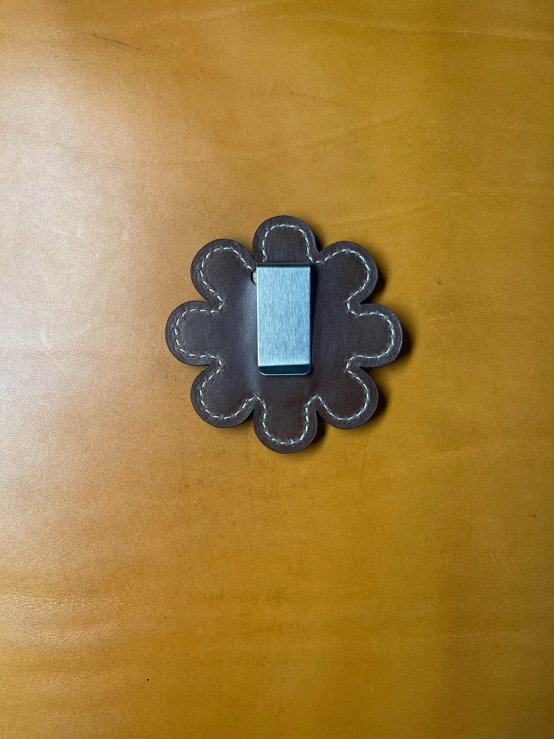 Backside of the Daisy glove holder showing the smooth finish and sturdy clip mechanism.