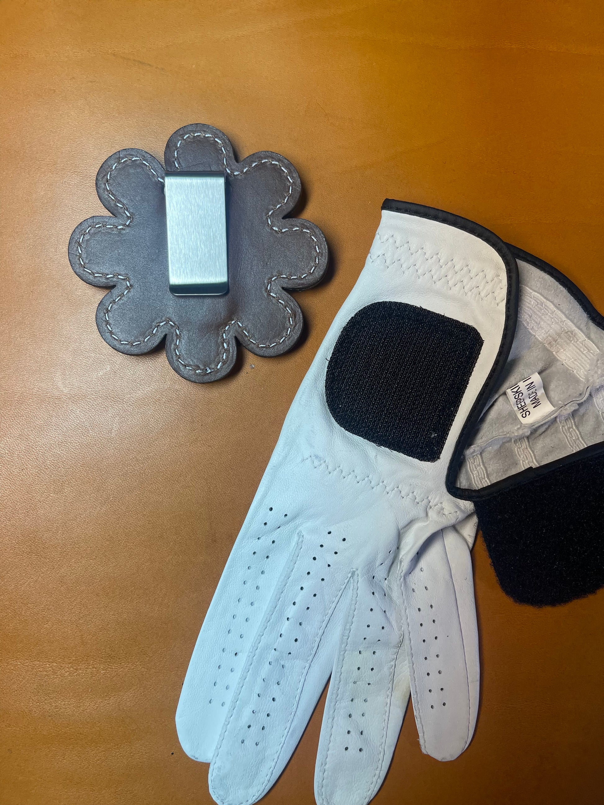 Backside of the Daisy glove holder showing the smooth finish and sturdy clip mechanism.